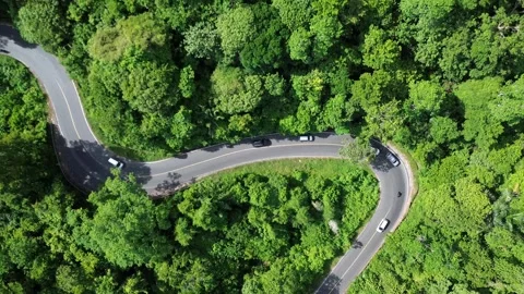 Drone view shows numerous vehicles traversing a winding road Stock Footage 342343462