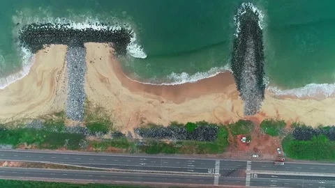 A drone view shows a sandy beach with ocean waves and a coastal highway run.. Stock Footage 334319877