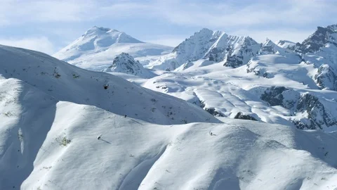 Drone view of skiers freeride skiing down on snowy hill in Alaska Stock Footage 129118010