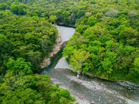 Drone view of small jungle river with washed up stones in an intact natural  Stock Photos