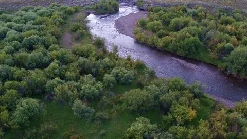 Drone view of a small river transforming in a waterfall on top of a creek Stock Footage 96162722