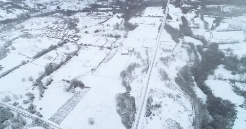 A drone view of a small village and fields under a blanket of snow. Stock Footage 314542742