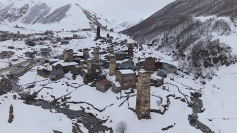 Drone View of Snow-Covered Ushguli and River in the Caucasus Winter Landscape Stock Footage 346738745