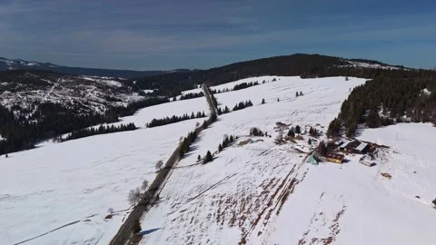 Drone view of snowy Tatra mountain road and farmhouses near Ždiar in winter Stock Footage 346312595