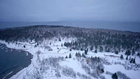 Drone view soaring over a breakwater blanketed in fresh snow along Lake Stock Footage 341435343
