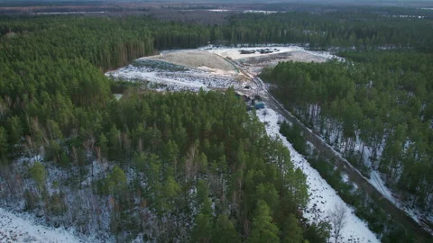 Drone view of a solid waste landfill in a snowy, wooded area Stock Footage 284504105