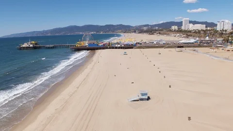 Drone view of sparsely populated Santa Monica Beach and pier during Coronavirus Stock Footage 127984891