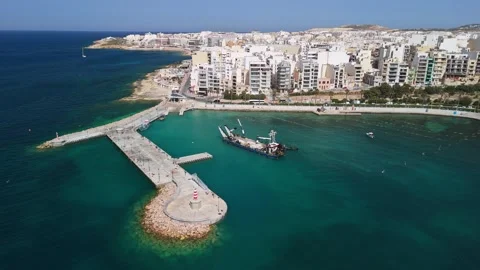 Drone view of St Paul's Bay harbor dredging near Malta breakwater works Stock Footage 339327074