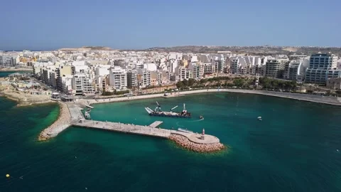 Drone view of St Paul's Bay harbor and dredging vessel near Bugibba jetty Stock Footage 339327081