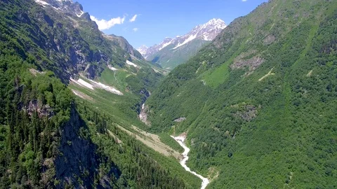Drone view of stormy river flowing from  mountain on background of snowy peak Stock-Footage 94596116