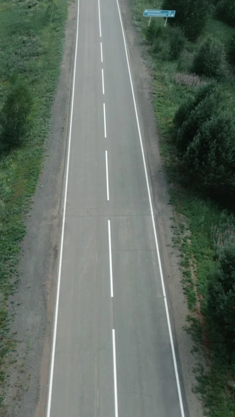Drone view of straight empty highway across forest and fields in Ural region Stock Footage 346558691