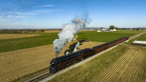 Drone View of a Streamlined Passenger Train Traveling Blowing Smoke Stock Photos