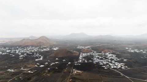 Drone view Stunning aerial view of white houses nestled among volcanic mountains Stock Photos