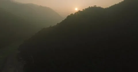 Drone View of Sun Rising Behind Mountains in Rishikesh Stock Footage 328712381