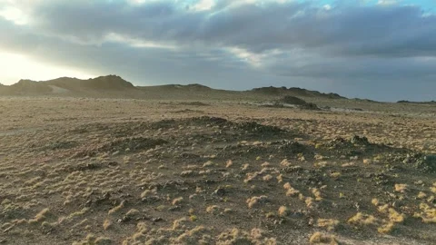 Drone view Sunbeams over rugged coastal mountains, turquoise sea at golden hour Stock Footage 337955727