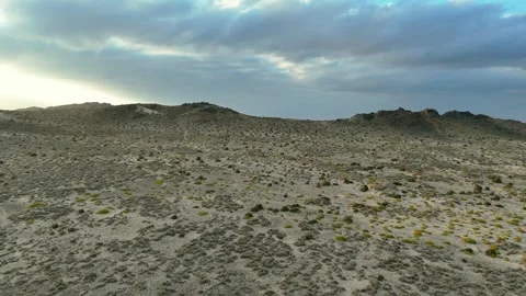 Drone view Sunbeams over rugged coastal mountains, turquoise sea at golden hour Stock Footage 337955997