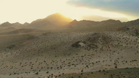 Drone view Sunbeams over rugged coastal mountains, turquoise sea at golden hour Video stock 337956189