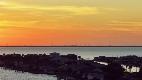 Drone view Sunset behind distant Windfarm over a gulf coast bay Video stock 307367622