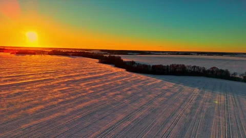 Drone view of sunset over a snow covered field. Stock Footage 317625859