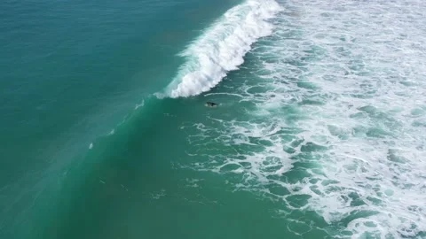 Drone view of surfer doing a duck dive under a big atlantic surf wave in Cadiz Stock Footage 143657098