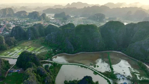 Drone view of Tam Coc valley in Vietnam at sunset, Ngo Dong River at Limestone Stock Footage 262809412
