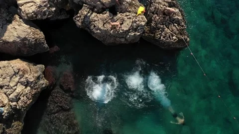 Drone view of three people diving into water simultaneously Видео 238701070