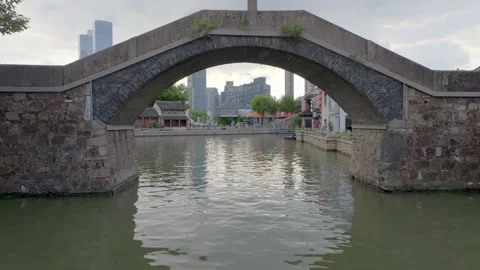 Drone view through a stone bridge arch on Wuxi Grand Canal Stock Footage 345045269