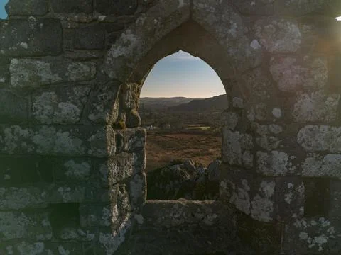 Drone view through stone window at Roche Rock chapel, Cornwall Foto stock
