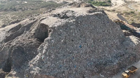 Drone view of a tire recycling facility with a large pile of old car tires Stock Footage 294722741