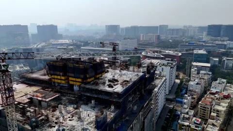 A drone view of a tower mid-build steel, Crane scaffolds, and safety nets wrap Video stock 328961569