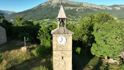 Drone view, tracking backwards, of the historic clock tower in a French mountain Stock Footage 312948153