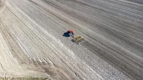 Drone view of a tractor preparing field at spring Stock Photos