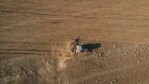 Drone view of tractor with towed harrow handles ground in autumn after harvest Vidéo 106984575