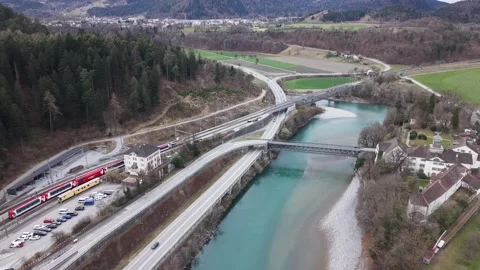 Drone view of train departing station over river and highway 스톡 동영상 330749142