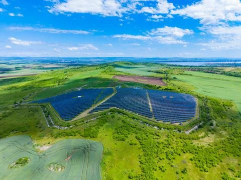 Drone view triangular solar array overlooking fields and patchwork farmland b 스톡 사진