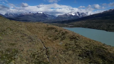Drone View of Turquoise Lake Surrounded by Snowy Mountains and Cloudy Sky Stock Footage 315091016