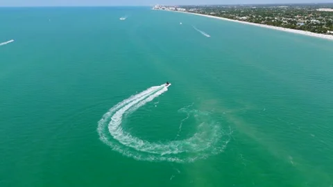 Drone view of turquoise waters of Naples, Florida. Motor boat making sharp turn Stock Footage 273832136