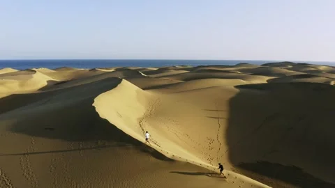 Drone view of two men running on sand dunes in Maspalomas, Gran Canaria Stock Footage 243195046