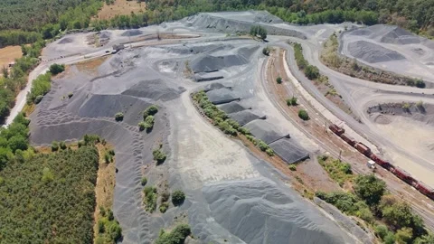 Drone view of Uzsabánya basalt quarry, rail cars and forested hills nearby Video stock 345508178