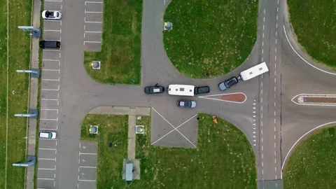 Drone view of vehicles with trailers navigating a road intersection beside Stock-Footage 316301023
