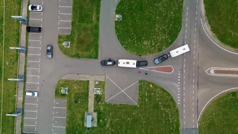 Drone view of vehicles with trailers navigating a road intersection beside Stock Footage 316496834
