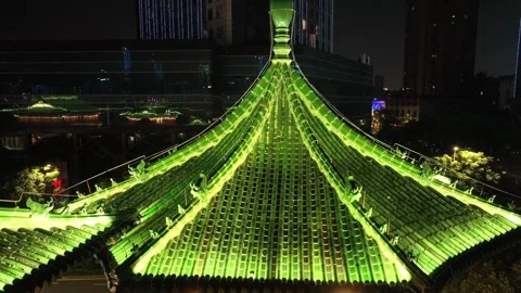 Drone view vibrant green lights highlighting a traditional Chinese pagoda Stock Footage 336716451
