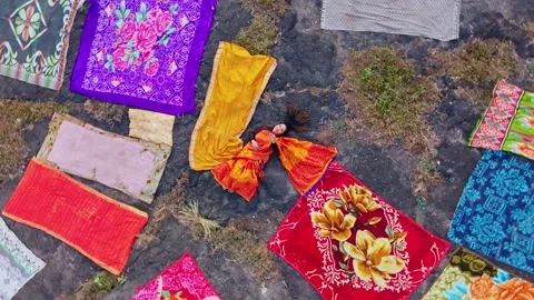 Drone view vocalist lying among bright fabrics outdoors Video stock 312032403
