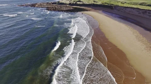 Drone View of Waves Rolling onto Golden Sandy Beach Coastline Video stock 333784371