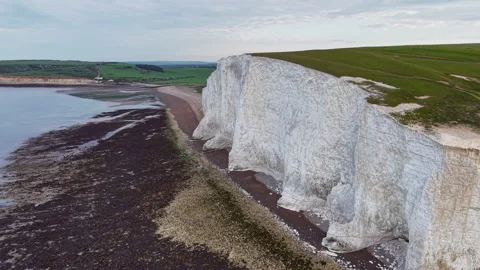 Drone view of white cliffs along green countryside and calm coastal river Stock Footage 309764991