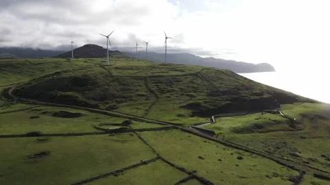 Drone view of wind energy mills by the sea in the green fields of the azores Stock Footage 142158297