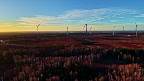 Drone view of wind turbines over patchwork farmland and forest at golden hour Stock Footage 325057509