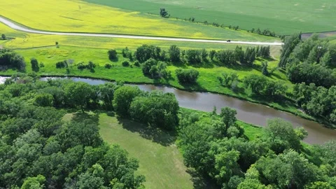 Drone view of a winding river through a lush summer landscape with fields. Stock Footage 312528056