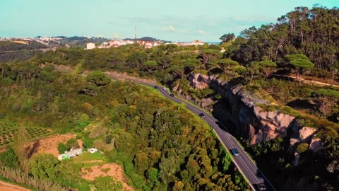 Drone view of a winding road in a mountainous area with moving cars Stock Footage 328745432