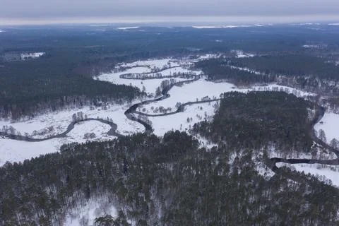Drone view of winter forest and curving river Stock Photos